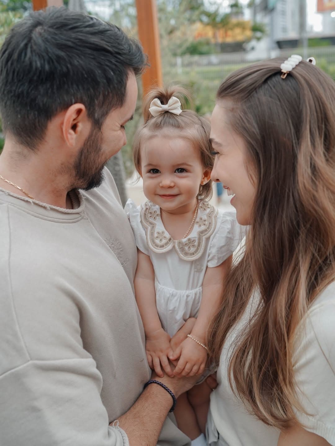 Rúbia e o marido segurando a filha pequena, os três se olhando